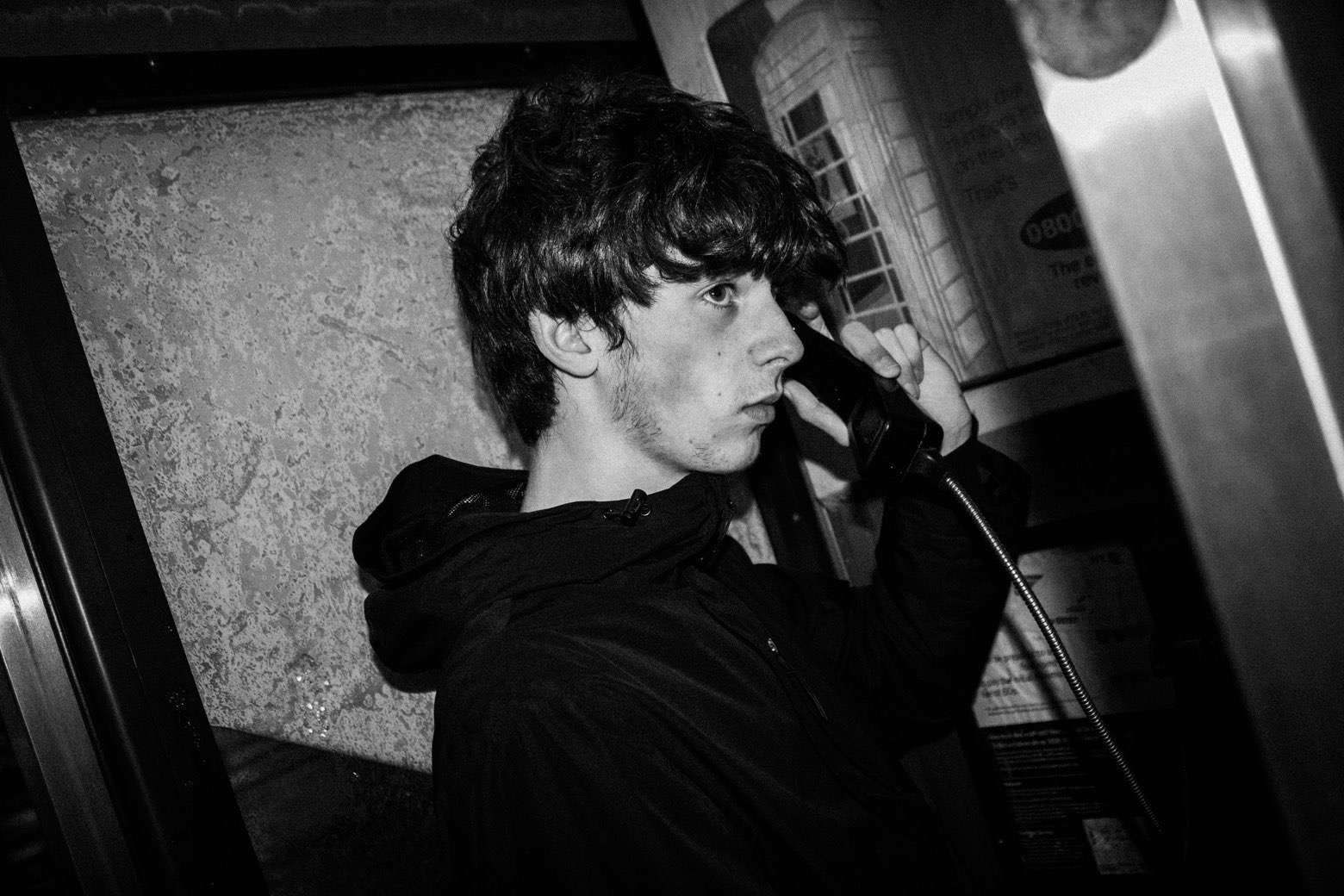 Band member in a phone box at night