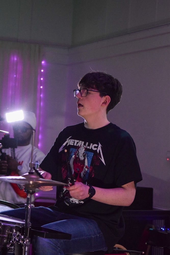 Drummer mid-set in purple light