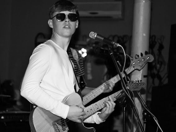 Max Thornhill of The Fleecers in sunglasses, singing into the mic with a Telecaster